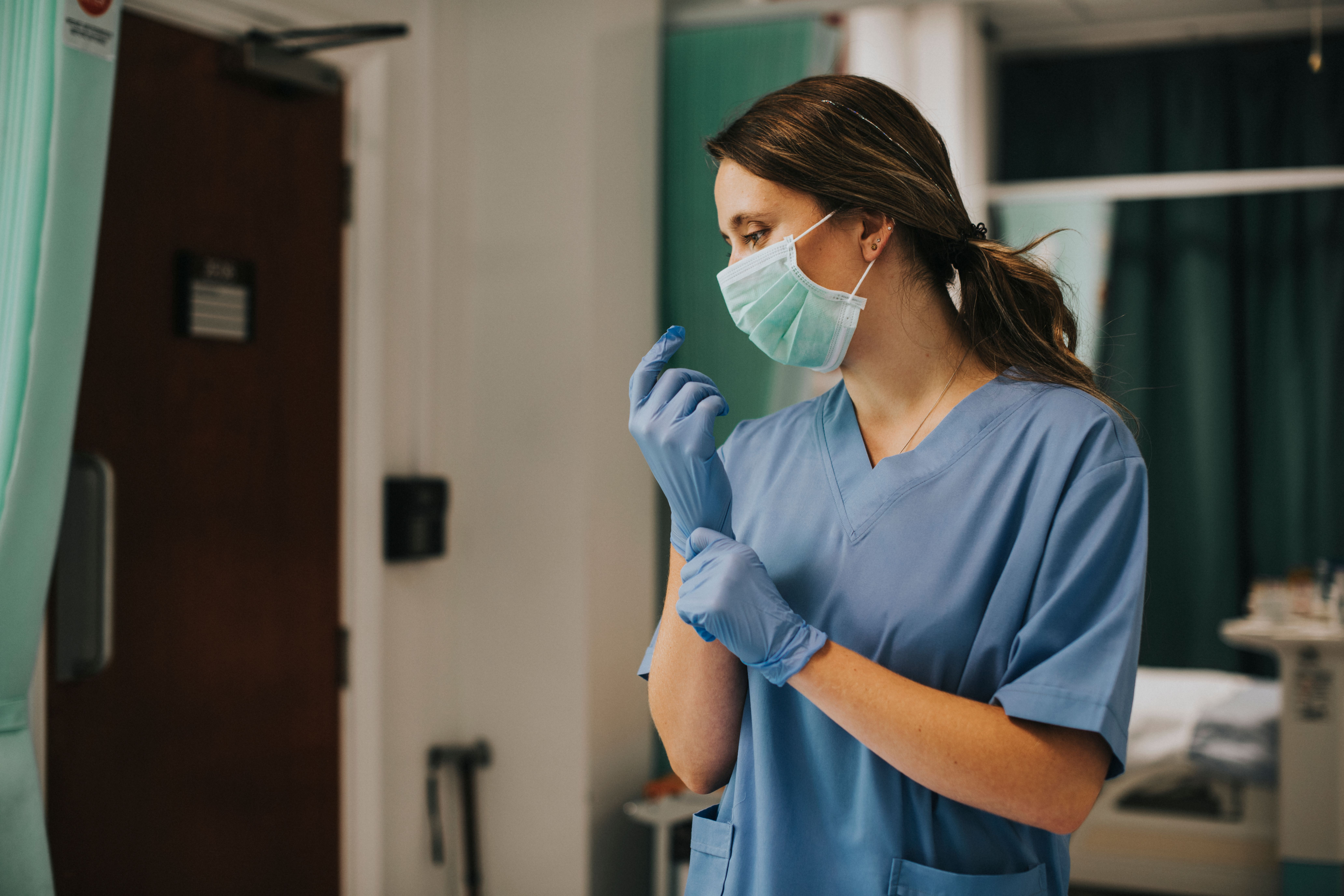 forensic nurse putting on gloves