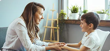 smiling counselor with young patient representing the online MSW tradiional program at Cleveland State University
